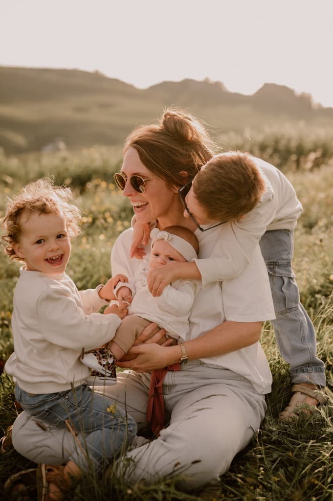 Julie et ses trois enfants dans un champ au coucher du soleil