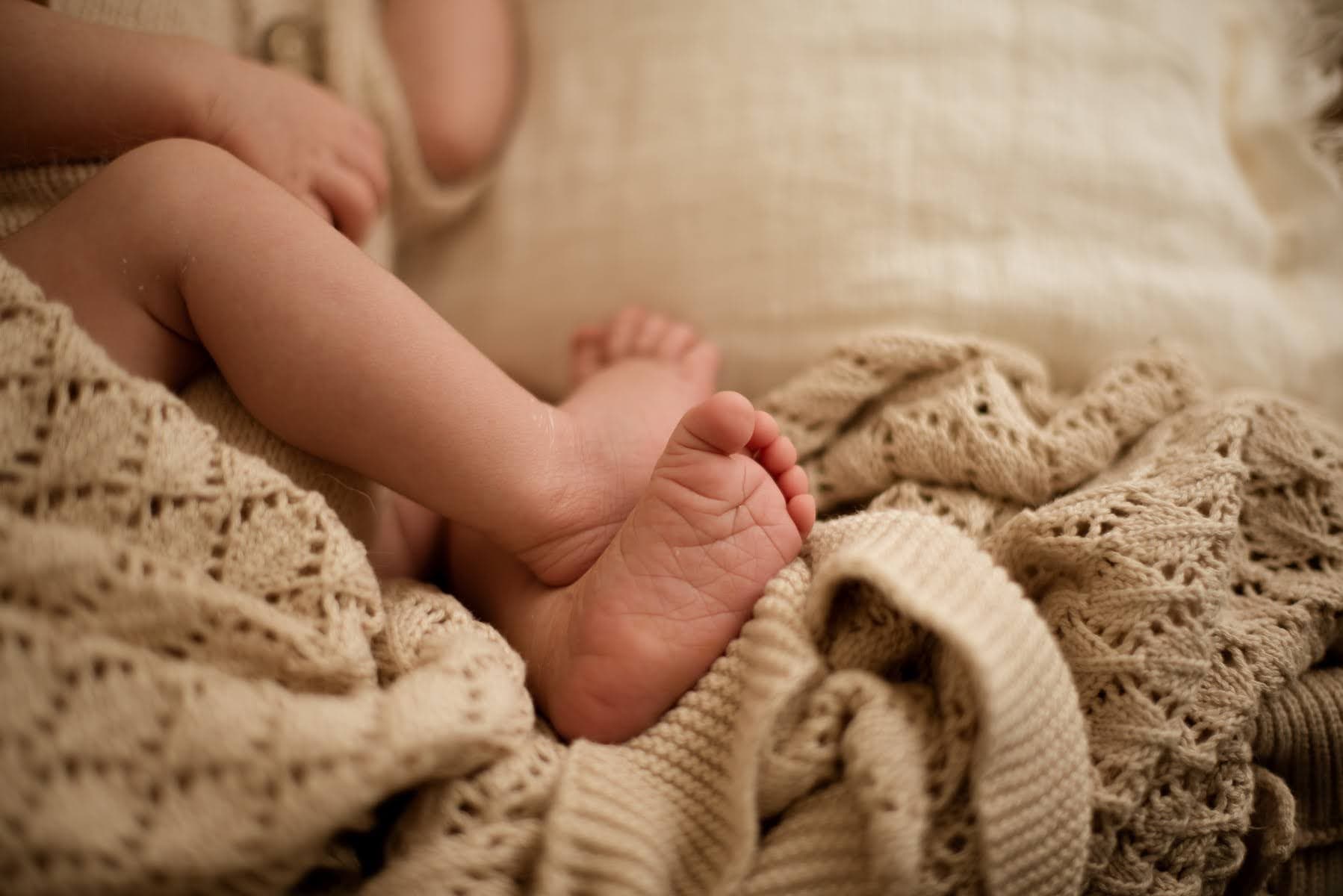 Mains tenant délicatement les pieds d’un bébé