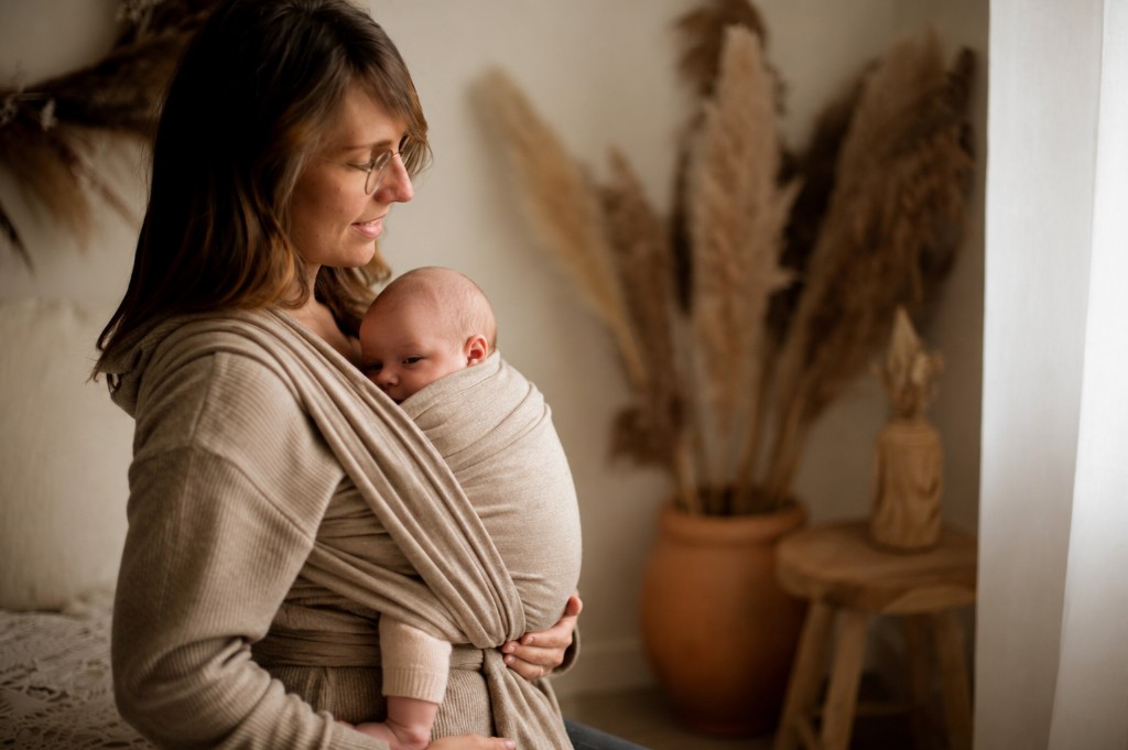 Parent portant son bébé en écharpe